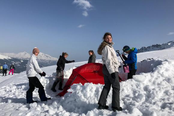 people building a tent in the snow