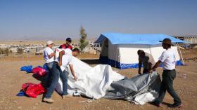 Fünf Personen bauen ein Zelt auf