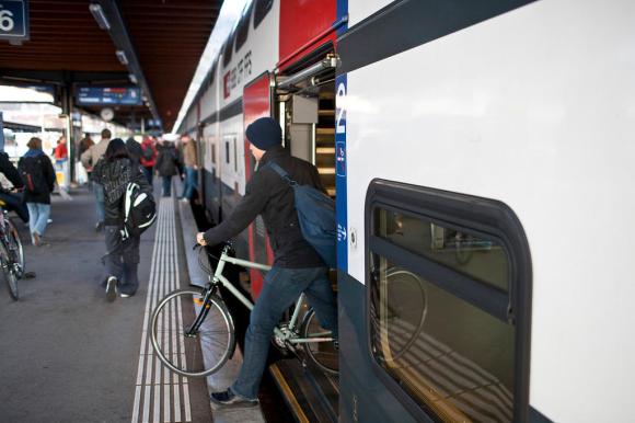 Man with cycle near train