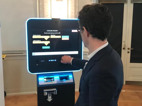 Mann bedient Bitcoin-Automaten