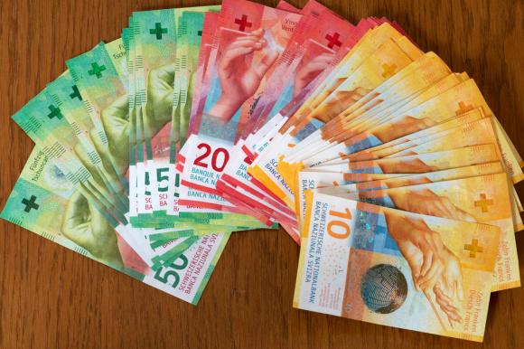 Swiss banknotes fanned out on a table