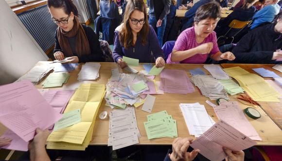 drei Frauen zählen Stimmzettel aus in der Stadt Zürich