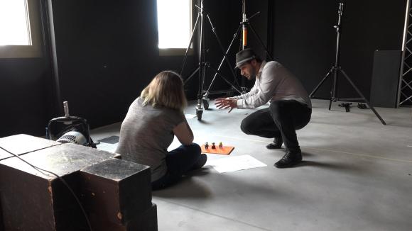 Estudantes de cinema preparam uma cena com storyboard no chão