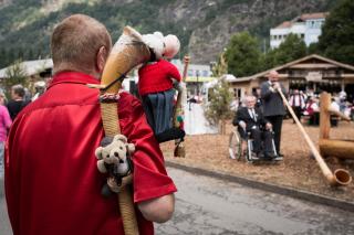 Rückenansicht eines Jodlers mit Plüschtierchen im Horn