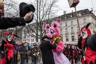 Carnaval de Basilea: un hombre entrega flores a una persona con disfraz de puerquita