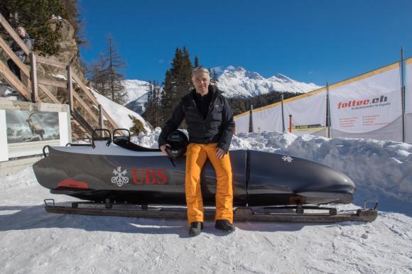 Sergio Ermotti resting against a snow mobile marked with the UBS logo