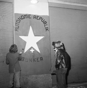 Jugendliche malen ein Schild Autonome Republik Bunker