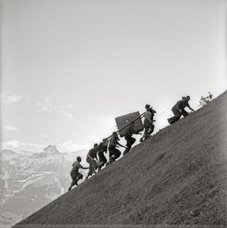 Unos hombres llevan una caja a la cima de una montaña
