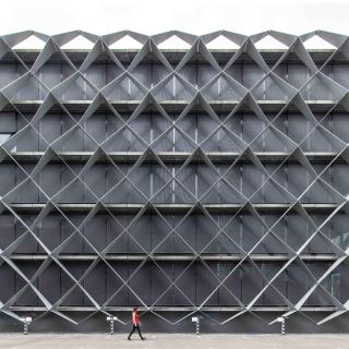 Gebäudefassade ohne Fenster mit Maschendrahtzaun-Muster