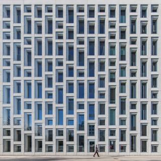 Modernes Bürogebäude mit horizontal unregelmässig und vertikal regelmässig angebrachten Fenstern