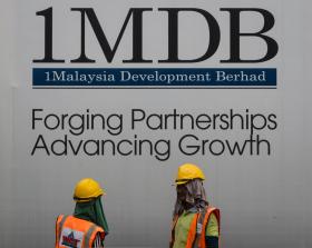 1MDB sign with workmen underneath
