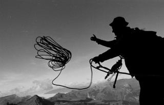 Silhouette von Bergsteiger in der Eiger-Norwand. Seilwurf.