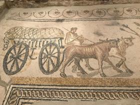 mosaic showing a four-wheeled roman vehicle