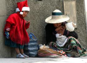 Mujer indígena sentada en el suelo con sus hijos