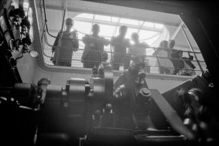 Passengers watch the pistons of a boat