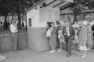 a group of people at a ticket kiosk