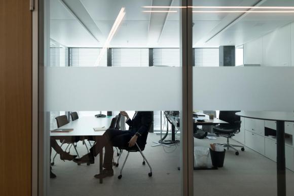 Employee in an office, seen through glass doors