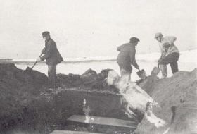 трое мужчин копают могилу