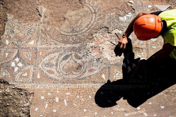 An archaeologist examines the Roman mosaic discovered in Avenches