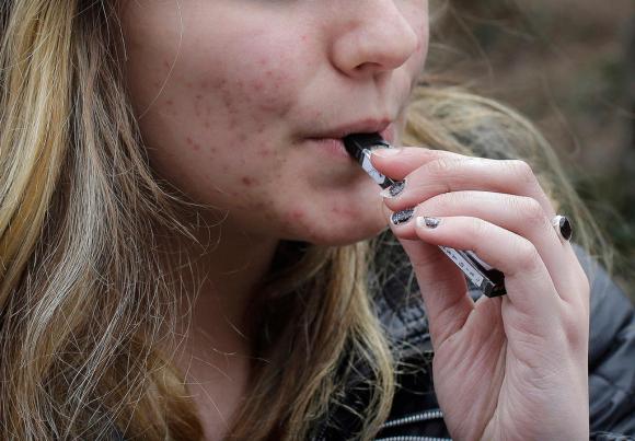 A woman smokes an E-cigarette