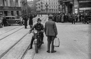 Ein Polizist auf einem Motorrad spricht einen Mann an