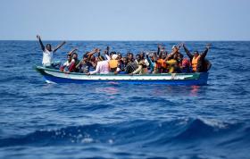 Migranten auf einem Kahn im offenen Meer