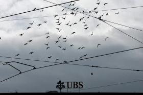 Pássaros voam por cima do logo do banco US