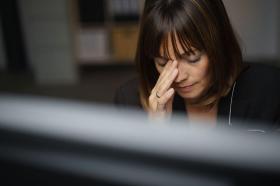 Mujer con dolor de cabeza en el trabajo