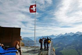 Des touristes sur une corniche surplombant les Alpes