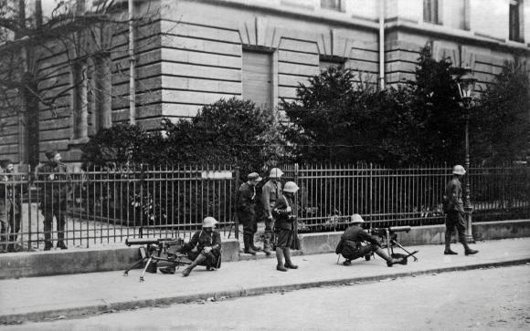 Soldaten und Maschinengewehre auf dem Bürgersteig