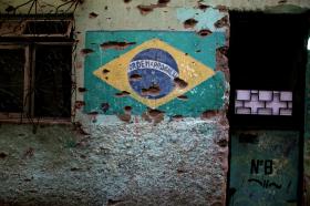 Bandeira do Brasil pintada na parede e crivada de buracos de bala