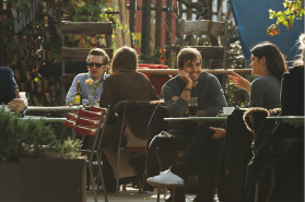 gente sentada en la terraza de una cafetería
