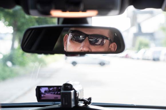 rostro de un hombre con gafas en el retrovisor de un coche