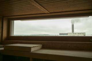 Sicht aus Saunafenster auf rauchenden Kamin