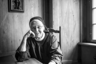 Klosterfrau sitz und lächelt in die Kamera