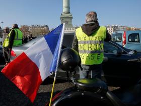 Demonstrant mit gelber Warnweste und französischer Flagge in Paris