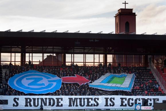 Supporters of a football stadium unfurl a banner