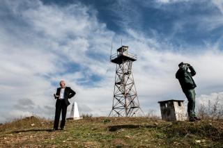 Dos hombre en una colina ante una torre de vigilancia