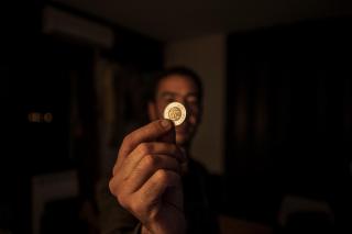 A man holds up a coin.