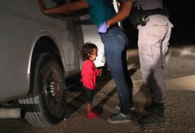 A Honduran child cries while her mother is searched in McAllen, Texas