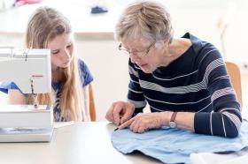 maestra enseña a coser a una joven