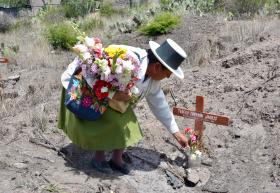 Mujer lleva flores a una tumba simbólica