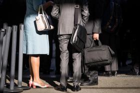 Men in dark business suits, woman in colourful business attire