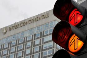 A traffic light in the foreground of an image of the Intercontinental hotel