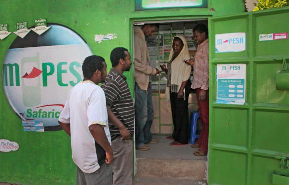 Dei clienti inviano e ricevono denaro allo sportello M-pesa di Nairobi in Kenya