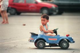 Chinese boy in a blue car