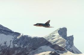 Imagen de avión Mirage 111 sobrevolando unas montañas.