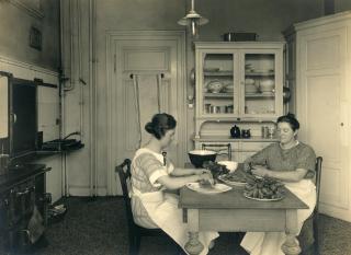 Deux femmes assises à une table coupent des légumes