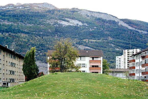 Un quartier de maisons avec une montagne derrière