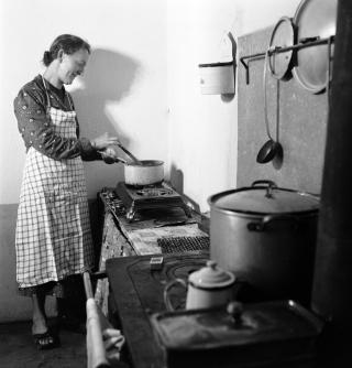 Une femme cuisine avec un poêle à gaz